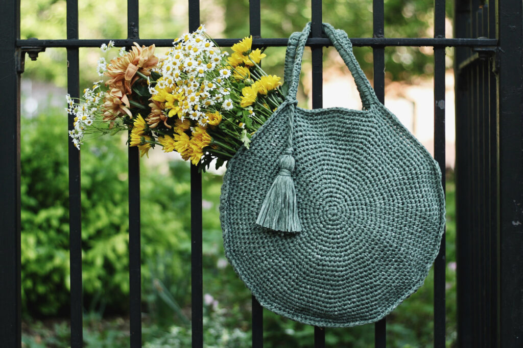 Stylish circular crochet Capri bag with tassel embellishments – modern crochet bags patterns.