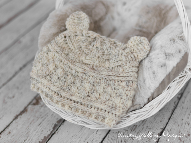 A cozy cream-colored crochet hat with playful pom-poms, perfect for adding charm to infant crochet hat patterns.