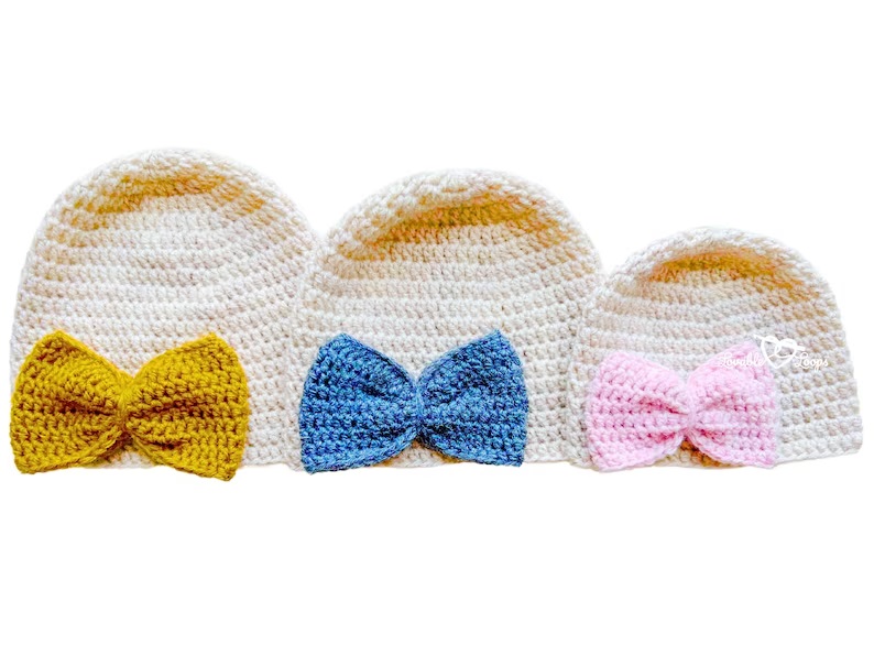Three cute crochet hats with colorful bows for infants, highlighting lovely infant crochet hat patterns that are perfect for stylish looks.