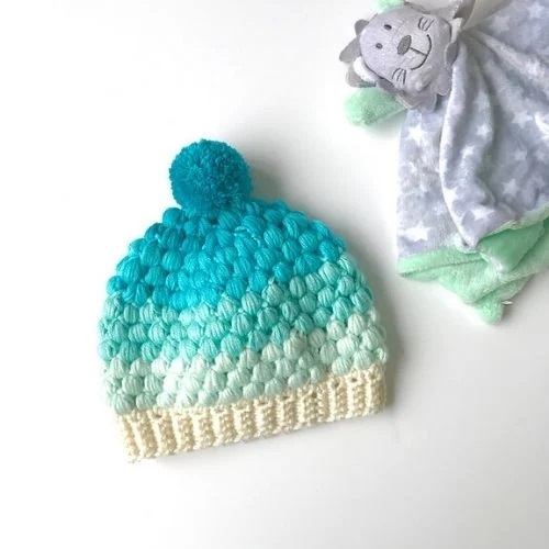 Colorful ombre infant crochet hat patterns featuring a fluffy pom-pom.