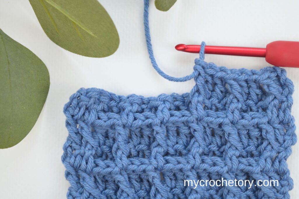 Red hook working the waffle stitch crochet pattern.