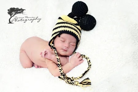 Whimsical infant crochet hat patterns resembling a bumble bee, complete with wings and stripes.