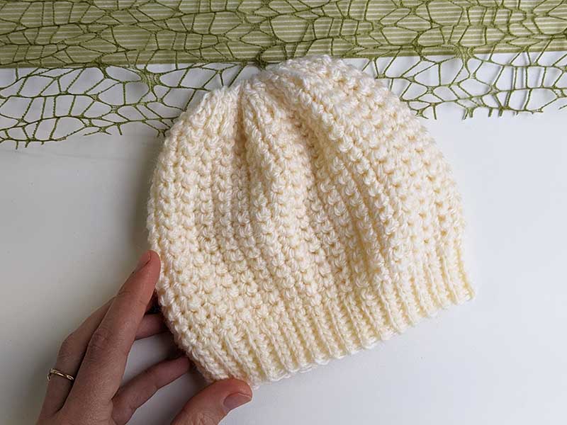 Soft cream-colored newborn crochet hat, perfect for keeping little heads warm with infant crochet hat patterns.