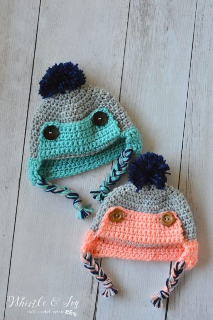 A pair of fun crochet baby hats with buttons and braids, ideal examples of playful infant crochet hat patterns.