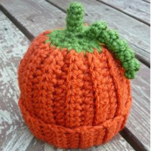 Adorable orange infant crochet hat patterns resembling pumpkins, featuring a green stem on top