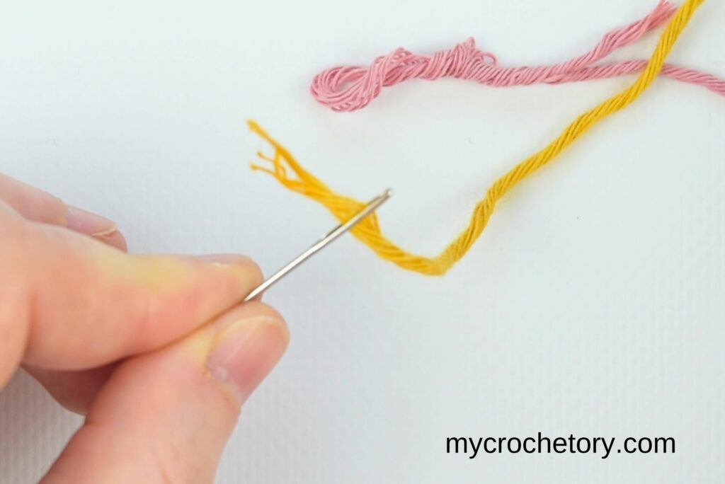 Preparing yellow yarn with a needle for how to do a Russian join.