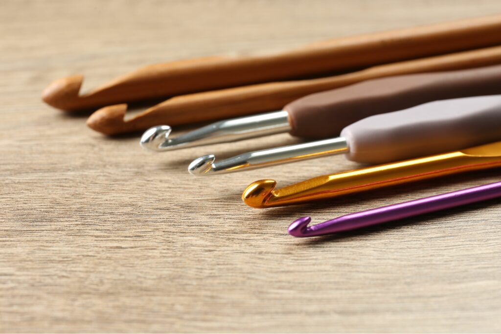 Variety of crochet hooks in different materials, helping beginners choose the right tool for beginning crochet stitches.