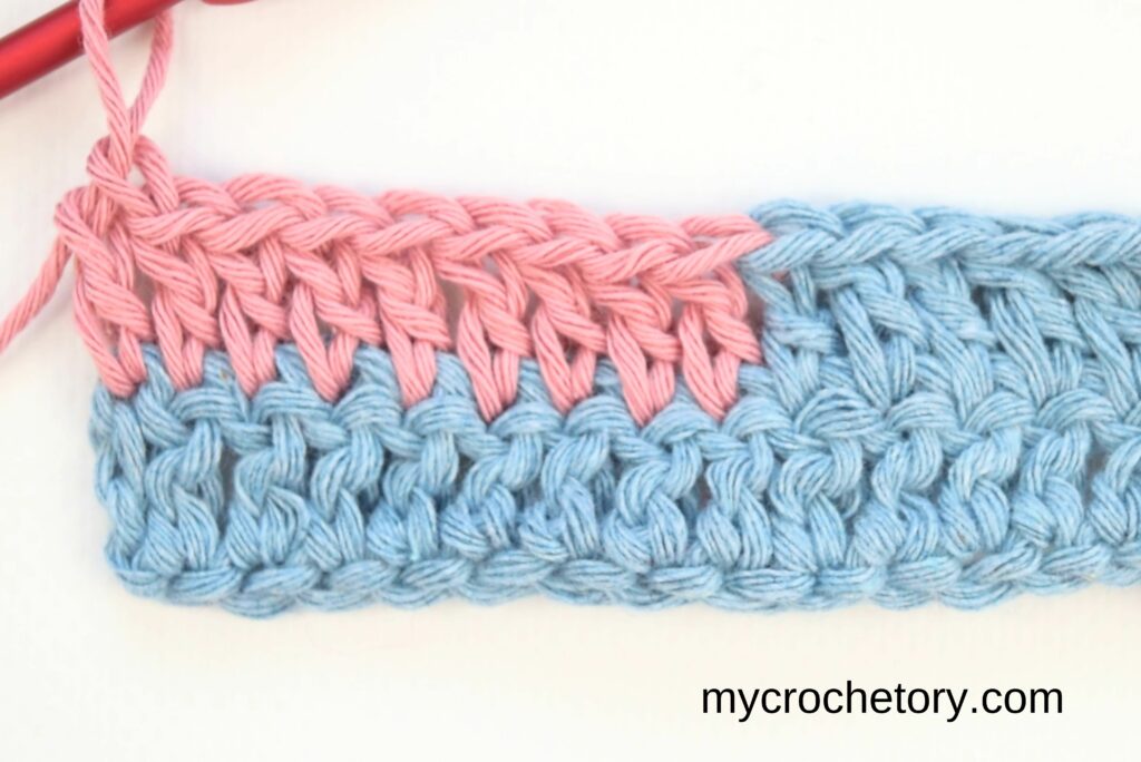 A smooth color change from blue to pink yarn, showing how to join yarn ends.