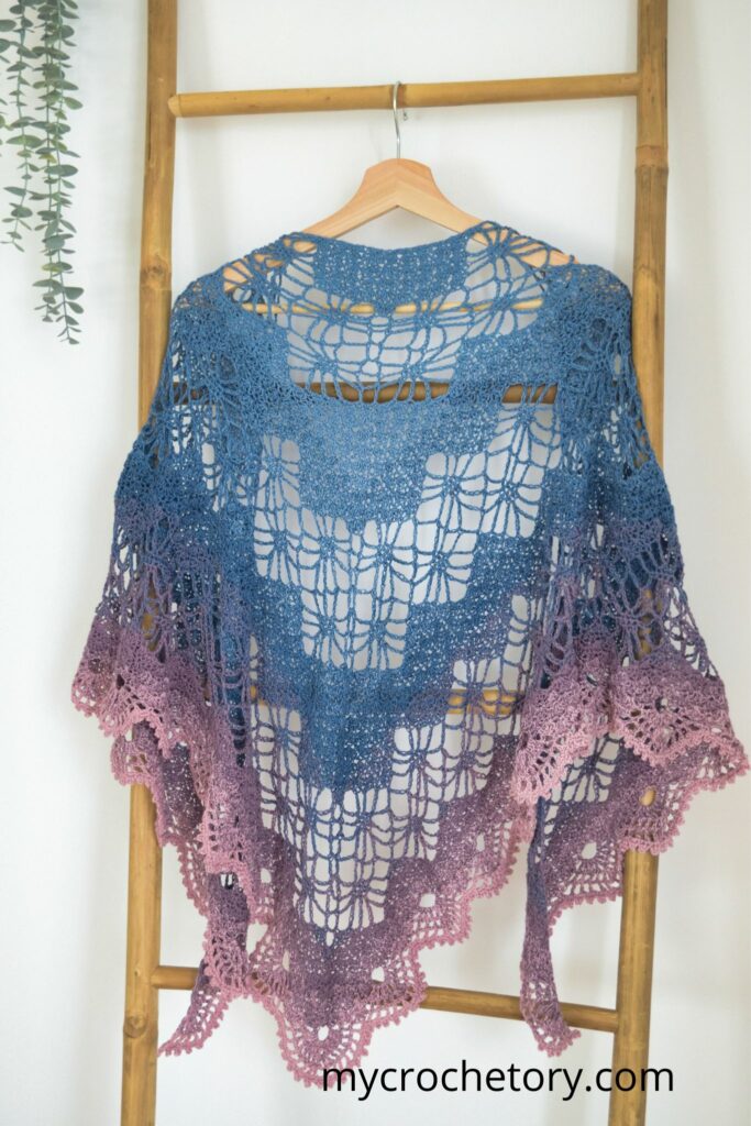 Beautiful display of the Arys Shawl, a Diagram Triangle Crochet Shawl Pattern worked with ombre yarn.