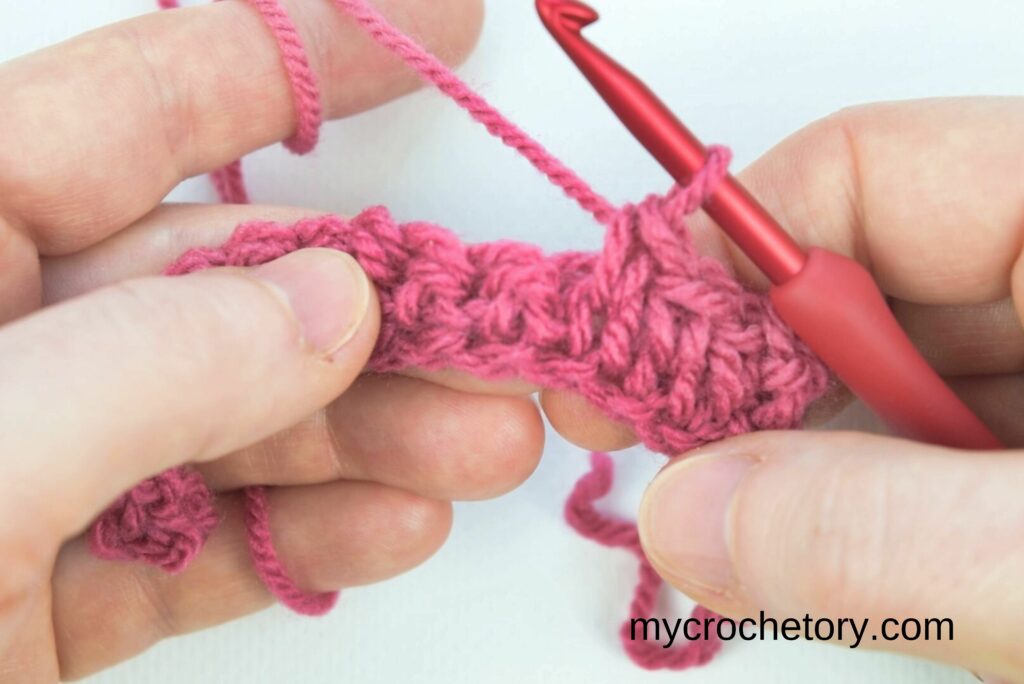 Working on the crochet waistcoat stitch to create the knit-look design.