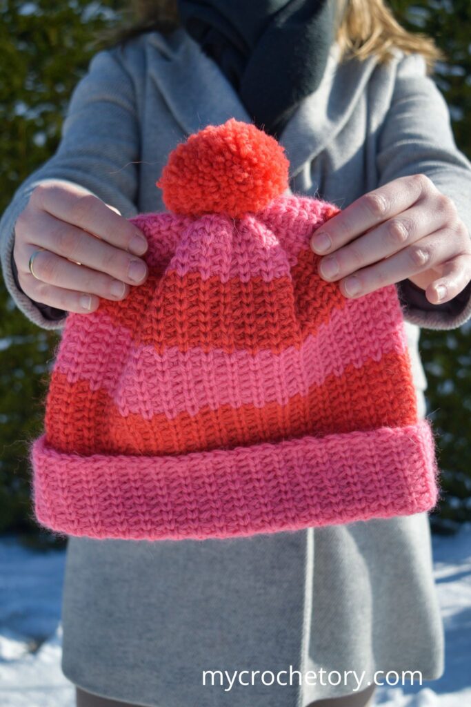 A bright, stylish fast crochet hat pattern with a seamless folded brim and bold stripes.