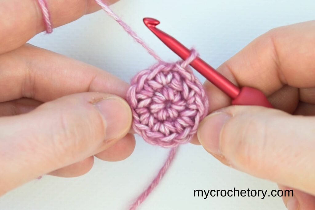 Early stage of how to crochet a circle using single crochet stitches worked into a magic ring.