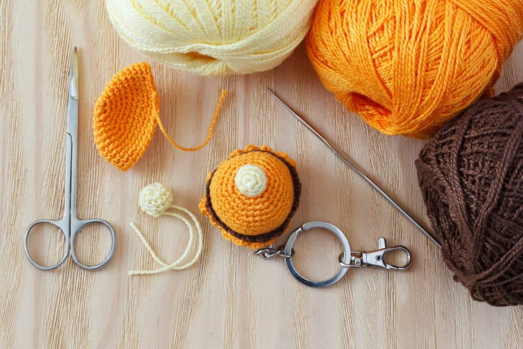 Small cupcake-shaped amigurumi keychain with yarn and hook — quick project perfect for trying easy crochet amigurumi tricks.