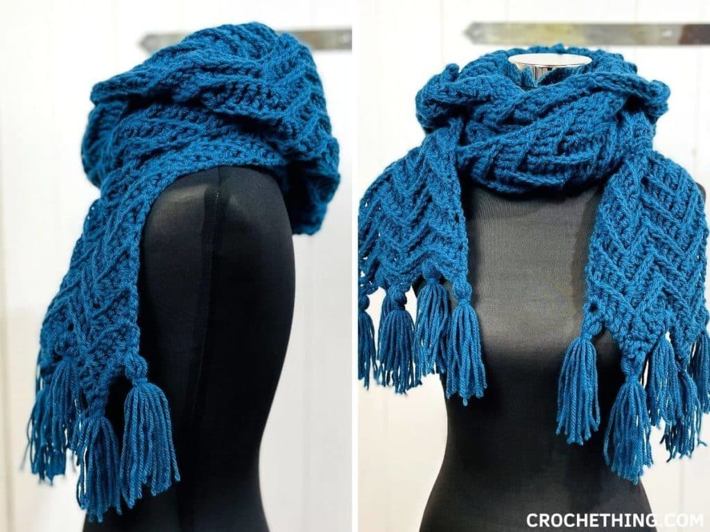 Blue chevron crochet hooded scarf with tassels, displayed on a mannequin, showing detailed textured pattern.