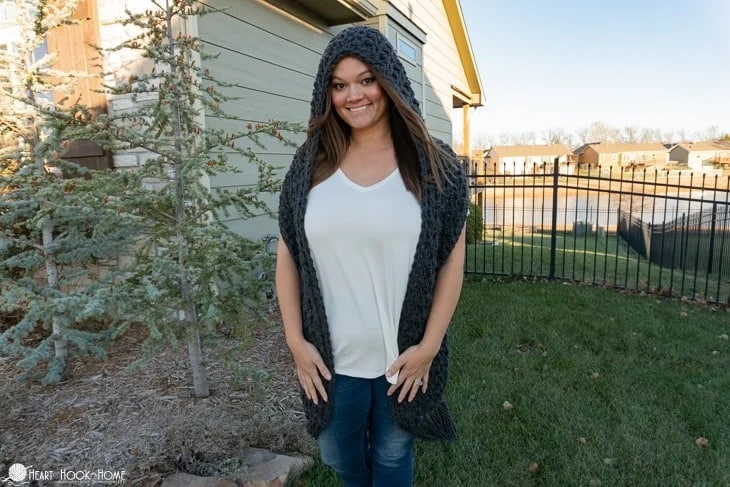 Woman wearing a thick crochet scoodie in dark gray yarn, cozy and soft for cold-weather wear.