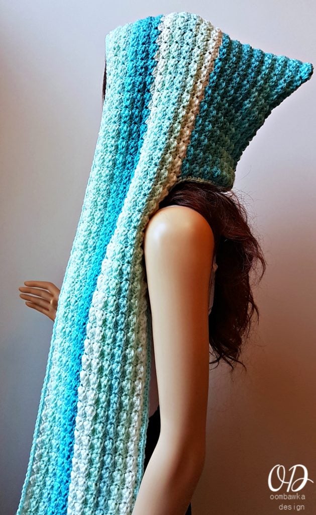 Crochet hooded scarf with gradient blue and white stripes, featuring a long, textured stitch design.