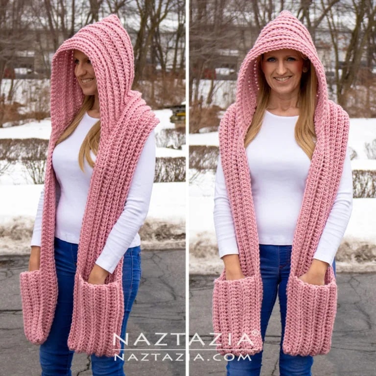 Woman wearing a pink crochet hooded scarf with deep front pockets, made from thick textured stitches and perfect for cold weather.