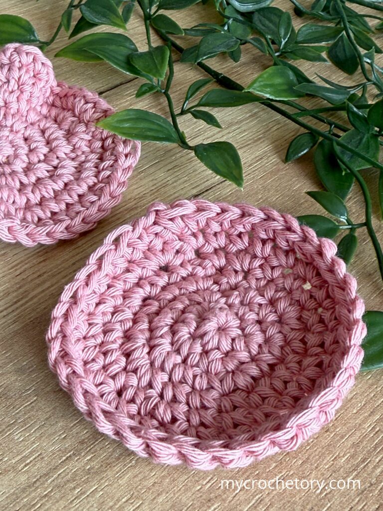 Close-up of a crochet circle curling into a cup shape due to tight tension or incorrect stitch count