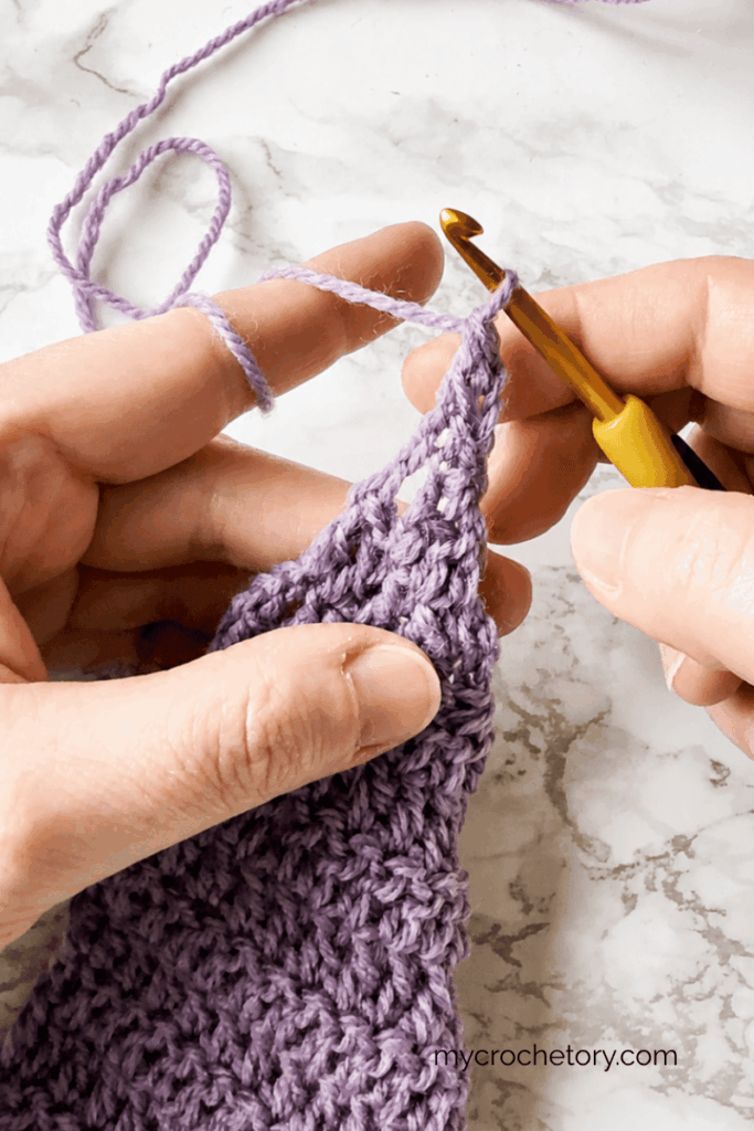 Final decrease rows of a tip to tip triangle crochet shawl tutorial
