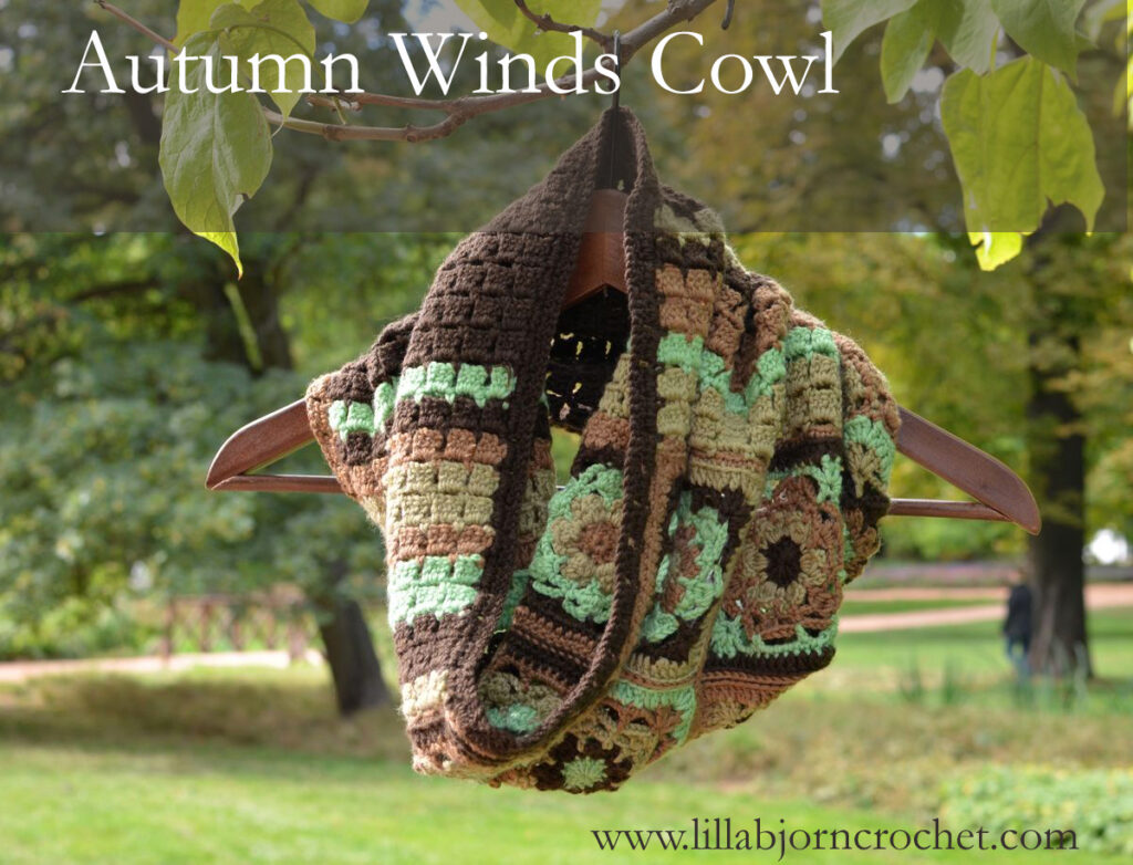 Autumn Winds granny square crochet cowl in brown, mint green and tan on a hanger outdoors
