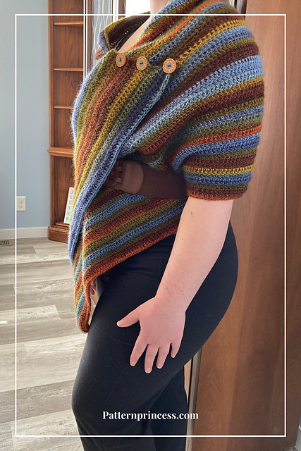 Beginner crochet poncho wrap in earthy variegated stripes with wooden buttons and a brown belt