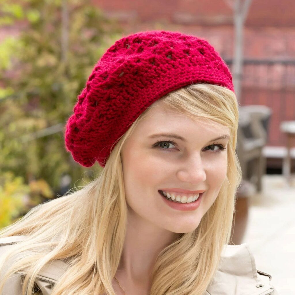 Bridgette lacy crochet beret in cranberry red, worn outdoors