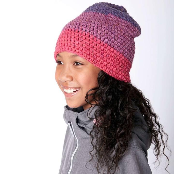 Girl wearing a slouchy striped crochet beanie in pink and purple