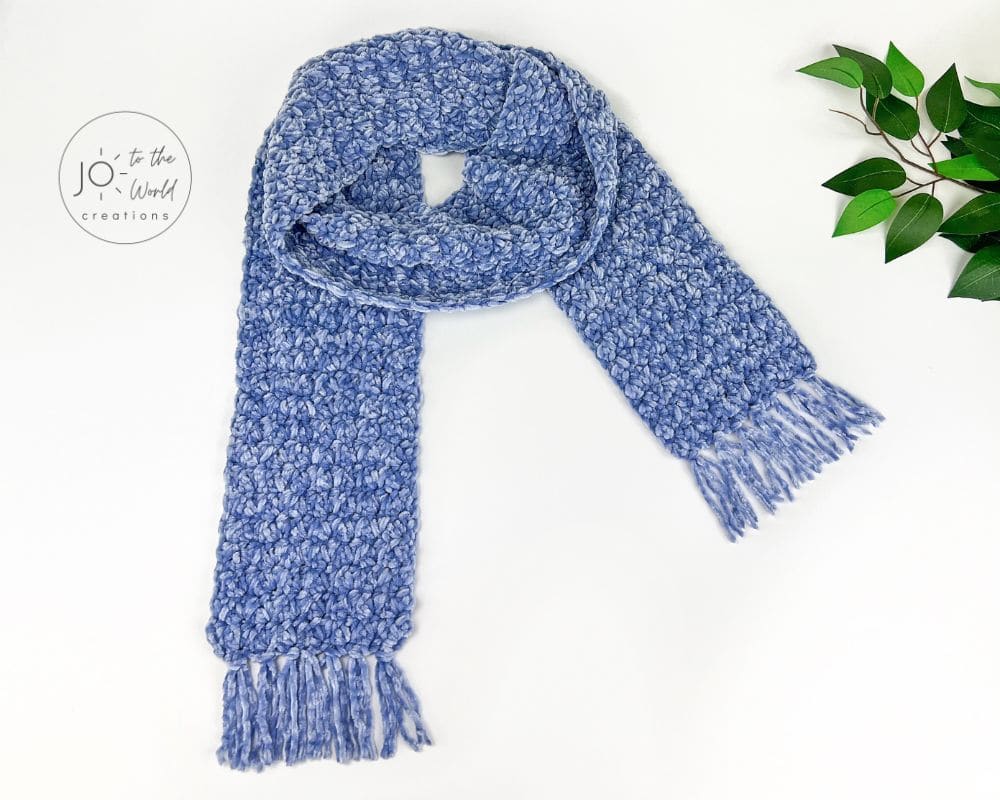 Chunky crochet scarf in blue velvet yarn with fringe at both ends