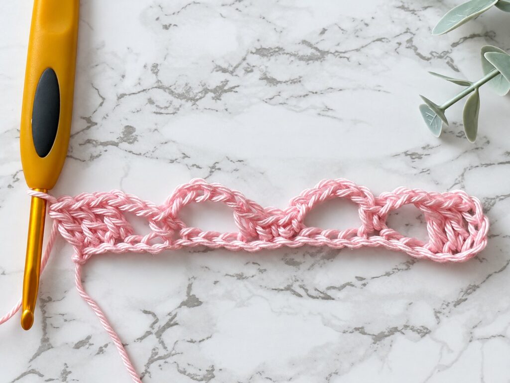 Sunny Lace Cowl row 1 with double crochet blocks and chain loops